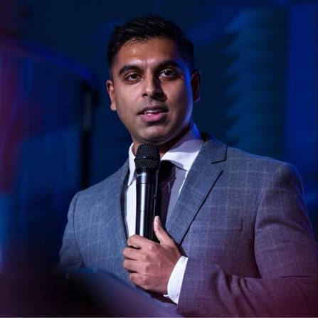 Ashvien Jitan spreekt met een microfoon in de hand